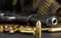 Single yellow brass bullet detail, black metal gun in background Royalty Free Stock Photo