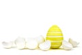 Single yellow easter egg between egg shells on white Royalty Free Stock Photo