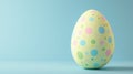 Single yellow easter egg with pastel polka dots on a blue background, perfect for holiday designs Royalty Free Stock Photo