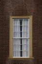 Single yellow framed window on red brick wall. Royalty Free Stock Photo