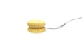 Single yellow macaron or macaroon cake on a fork on white background. side view, close up, copy space Royalty Free Stock Photo