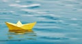A single yellow paper boat floating on blue water - symbolic of future prospects