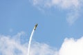 Yellow stunt plane climbing trailing a smoke contrail