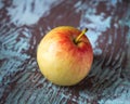 Single yellow-red apple on motley wooden background Royalty Free Stock Photo