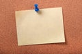 Single yellow sticky post note pinned pushpin cork board background Royalty Free Stock Photo