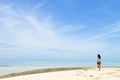 Single young Asian girl walking on tropical white sand beach Royalty Free Stock Photo