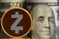 Single Zcash coin in front of bank rolls of US currency