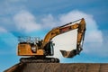 Cat yellow heavy machinery excavator digger on a road construction site