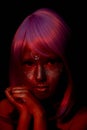 Sinister look, mysticism and mystery. A girl with purple hair and glowing skin. An alien or a fairy with glowing skin. Royalty Free Stock Photo