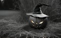 A sinister, scary pumpkin in a witch\'s hat against a background of grass. Halloween. Black and white image Royalty Free Stock Photo