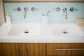 Sink faucets with hand wash, toothbrush and toothpaste in bathroom Royalty Free Stock Photo