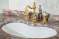 Sink made of expensive marble stone. Vintage design of faucet and taps, in gold and glass handles Royalty Free Stock Photo