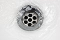 Sink plug drain hole bath plughole, white basin spout, running water macro closeup, stainless steel, china porcelain hand Royalty Free Stock Photo