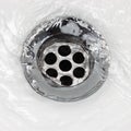 Sink plug drain hole bath plughole, white basin spout, running water macro closeup, stainless steel, china porcelain hand Royalty Free Stock Photo
