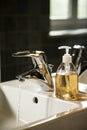 Sink with runnig water and liquid soap dispenser Royalty Free Stock Photo