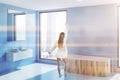 Sink and tub in blue bathroom corner, woman Royalty Free Stock Photo