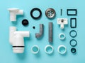 Sink waste water trap parts knolled on a blue background. Knolling style composition of new disassembled plastic sink drain with Royalty Free Stock Photo