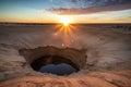 sinkhole in a desert, with the sun setting over the horizon