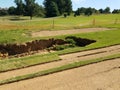 Sinkhole or erosion in grass and dirt on golf course