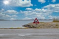 Sinking car road sign surrounded by the sea under a blue cloudy sky and sunlight Royalty Free Stock Photo