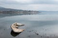 A sinking little boat on Trasimeno lake, Umbria, with Passignano town in the background Royalty Free Stock Photo