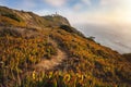 Sintra Portugal. Lighthouse on Cape Roca. Travel and hiking path lit by golden sunset light. Tourism landmark with Royalty Free Stock Photo