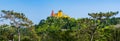 Panoramic skyline view of the National Palace of Pena and Castle of the Moors on the hill top surrounded by a green forest in Royalty Free Stock Photo