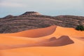 Sinuous Merzouga dunes and mountain at sunset, Sahara Desert, Morocco