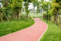 Sinuous red path in verdant spring Royalty Free Stock Photo