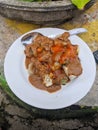 Siomay, Indonesian traditional street food with spicy peanut sauce and soy sauce, served with green lime on a white plate