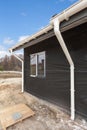 SIP panel house construction. New gray metal tile roof with white rain gutter. Royalty Free Stock Photo