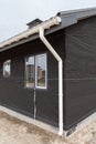 SIP panel house construction. New gray metal tile roof with white rain gutter. Royalty Free Stock Photo