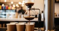 Siphon Coffee Maker Brewing Coffee into Disposable Cups in a Cafe Setting coffee shop Royalty Free Stock Photo