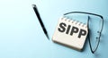 SIPP text written on a notepad on the blue background