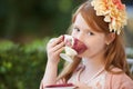 Sipping my tea...A young girl playing dress up and sipping from her tea cup in the garden. Royalty Free Stock Photo