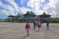 Sir Gaetan Duval Airport with arriving passengers walking into the building and dramatic sky with clouds