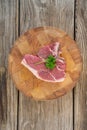 Sirloin chop and corainder leaves on wooden tray against wooden background