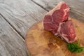 Sirloin chop and corainder leaves on wooden tray against wooden background