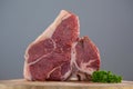 Sirloin chop and corainder leaves on wooden tray