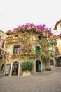 SIRMIONE, ITALY Facade of house in center of Sirmione with flowering pink bougainvillea.traditional summer facade decoration of a