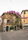 SIRMIONE, ITALY Facade of house in center of Sirmione with flowering pink bougainvillea.traditional summer facade decoration of a