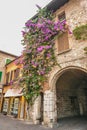 SIRMIONE, ITALY Facade of house in center of Sirmione with flowering pink bougainvillea.traditional summer facade decoration of a