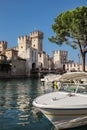 Small Boat on Lake Garda with View of Scaligero Castle in Italy