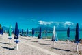 Sirmione, Italy - September 22, 2021: Closed umbrellas on the beach of Lake Garda