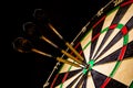 Sisal dartboard with three darts in a bullseye