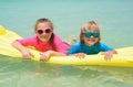 Sister and brother playing with air mattress at the beach Royalty Free Stock Photo