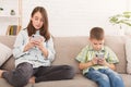 Sister and brother playing online games on smartphones