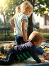 Sister and brother playing with sand. Adorable little kids family related in sandbox on playground. Happiness of play together