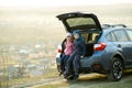 Sister and brother resting on fresh air near car Royalty Free Stock Photo