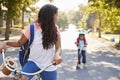 Sister With Brother Riding Scooter And Bike To School